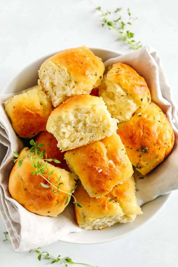 These pull-apart Honey Butter Dinner Rolls are light, fluffy and made without any yeast, eggs or oil.  Infused with honey and fresh herbs, these Parker House-style dinner rolls are perfect for your holiday table this season!