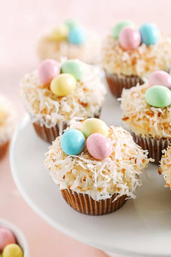 Celebrate Easter with these festive Bird's Nest Carrot Cake Cupcakes that are super moist, naturally sweetened with maple syrup and applesauce, all topped with a cream cheese frosting, toasted coconut and chocolate candies!